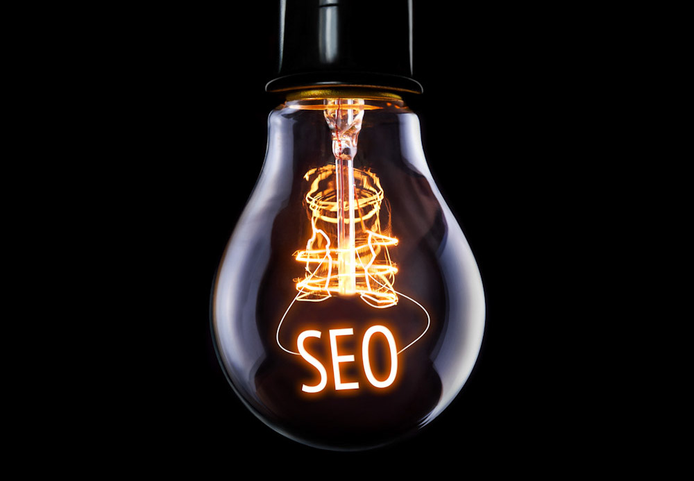 Hanging lightbulb with glowing SEO concept