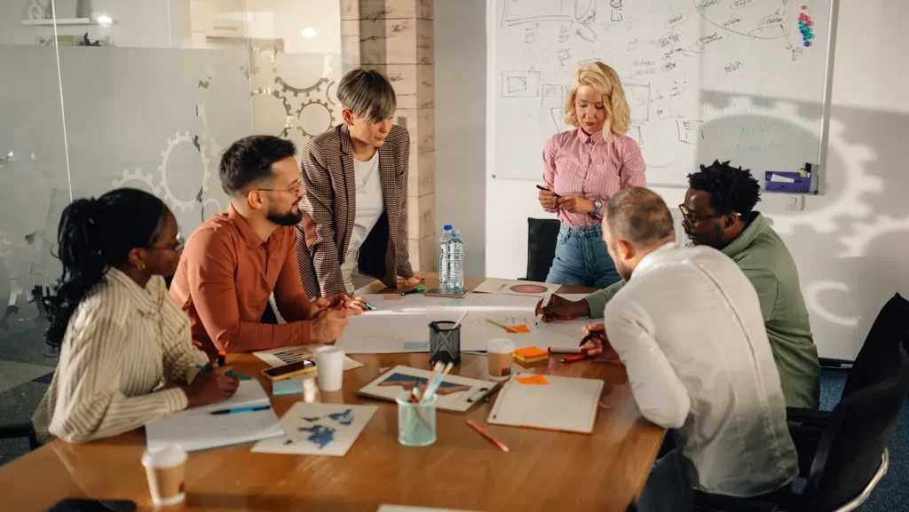 Marketing team analyzing diagrams and discussing new strategy during a meeting