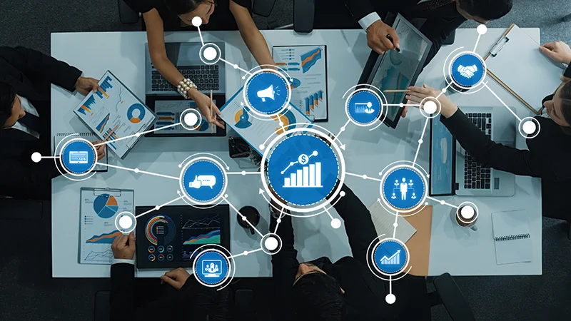 A dynamic business team engages in collaboration over data analysis using charts and graphs in a modern office
