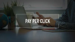A person sitting at a workstation with the phrase "pay per click" imposed over the front.