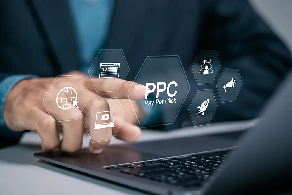 Businessman using laptop with PPC icon on virtual screen